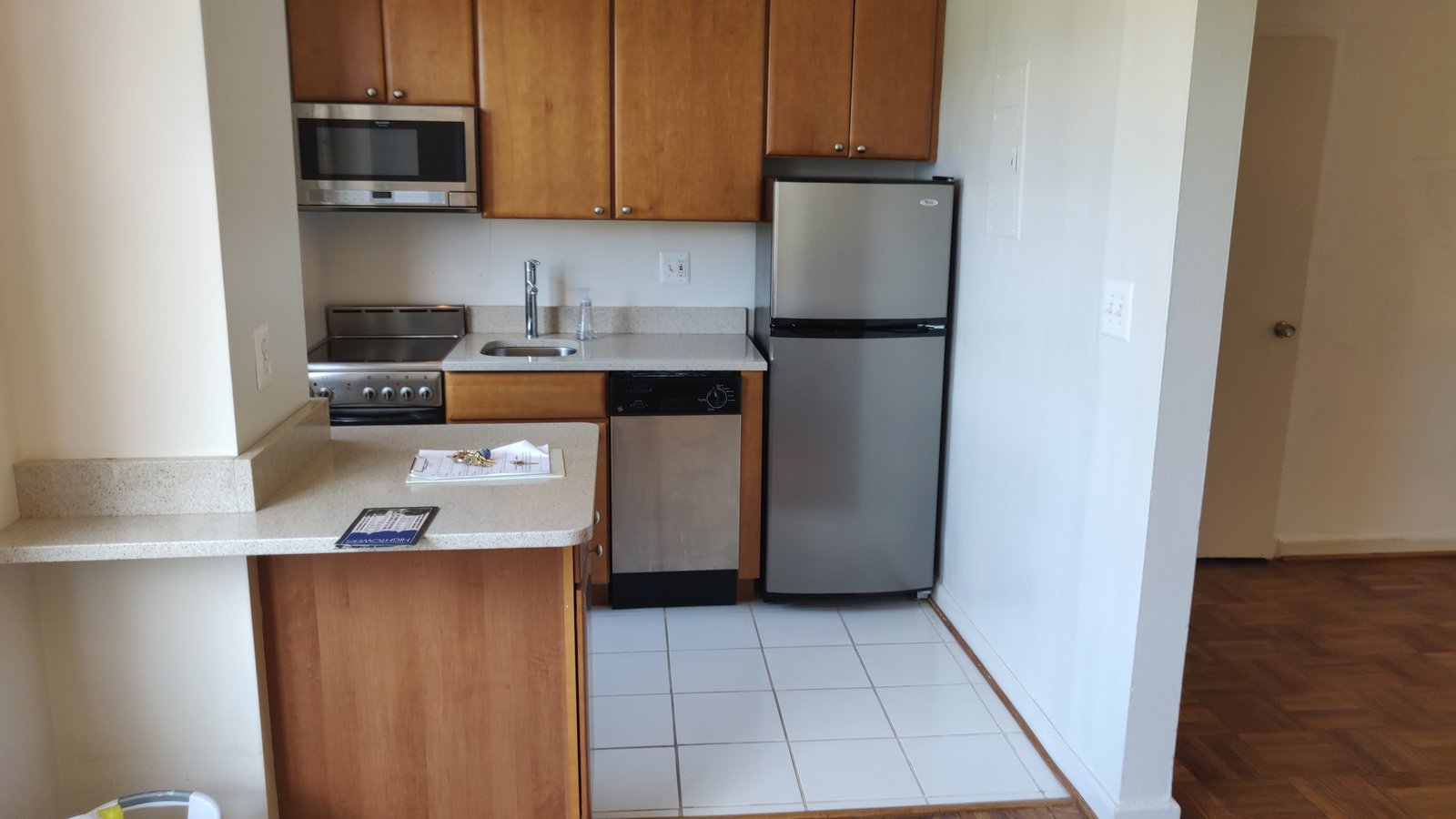 Cuisine compacte d’appartement avec réfrigérateur, cuisinière, lave-vaisselle et armoires